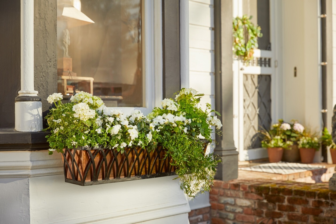 Arch design window box with copper liner planted with white flowers