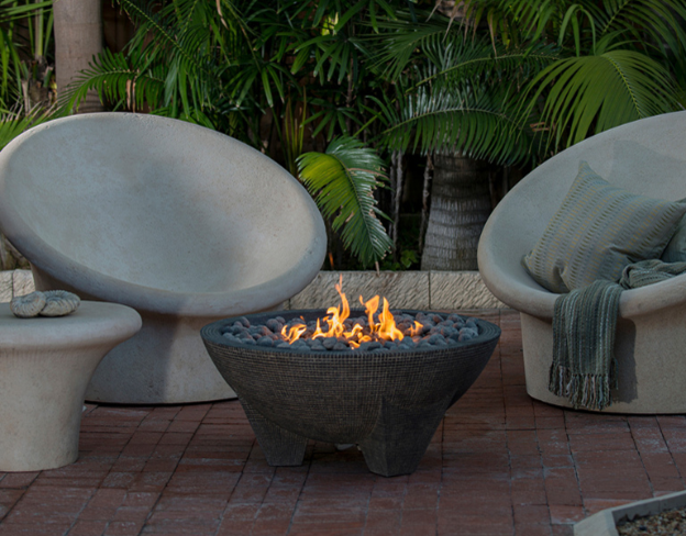 Gobi Fire Bowl with flames flanked by 2 modern cement chairs