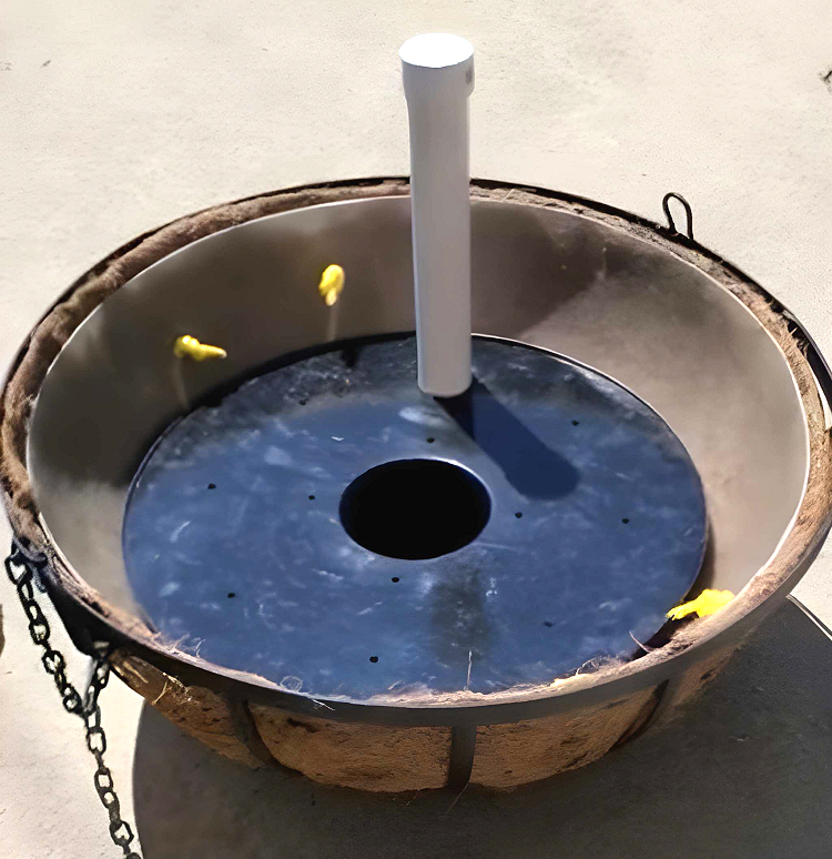 A self-watering reservoir is placed at the bottom of a hanging basket.
